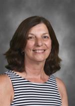 Angela Isetts has shoulder length hair, she is wearing a black and white striped shirt
