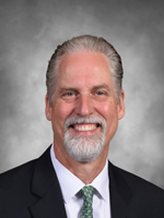 Peter Schiller   is wearing a dark business suit with a tie.