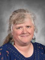 Elisabeth Riches is wearing. a blue shirt