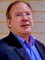 Neil Desnoyers is wearing a blue business suit and blue dress shirt